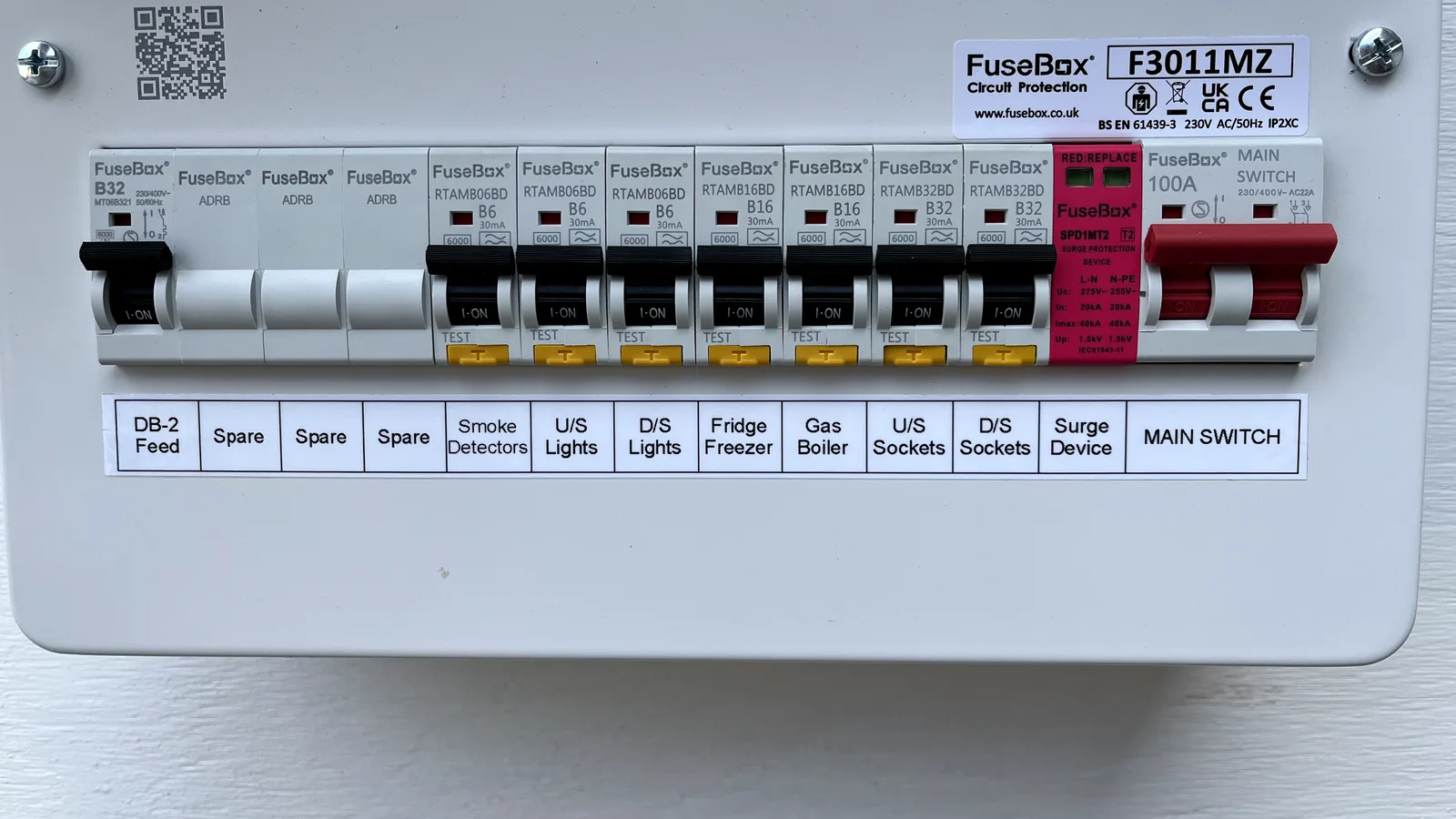 A modern consumer unit fitted by us: every circuit on its own RCBO with a yellow test button, a Type 2 surge protection device, and a printed label strip naming each circuit.